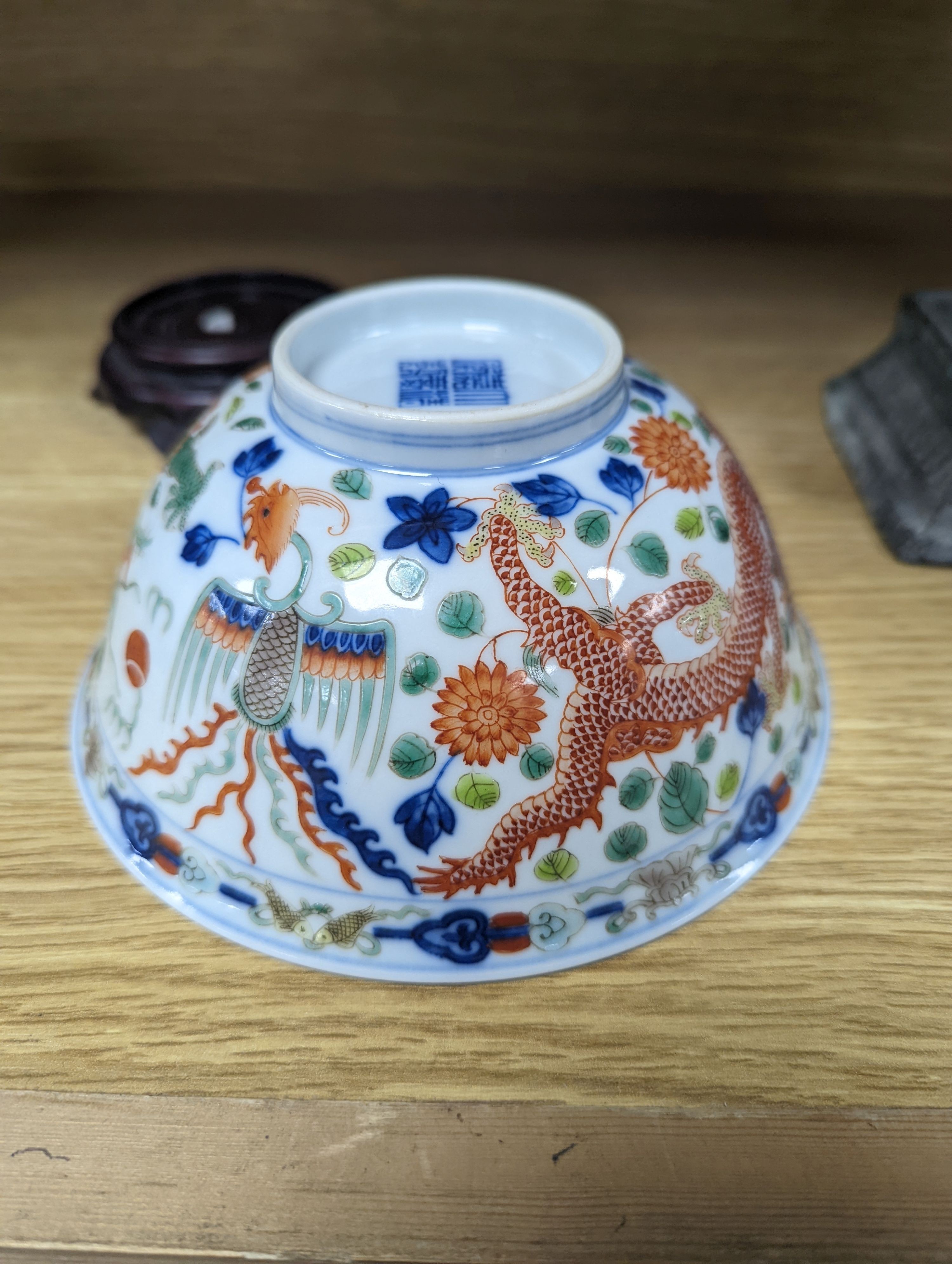 A Wucai bowl, dragon and flamingo pearl decoration, Jiaqing mark, on wood stand. 16cm diameter